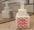 Bottle of 'journee bloom' hydrating wash on a bathroom counter with a mirror in the background.