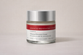 Jar of Advanced Recovery CreamCream with silver lid and red label on a beige background