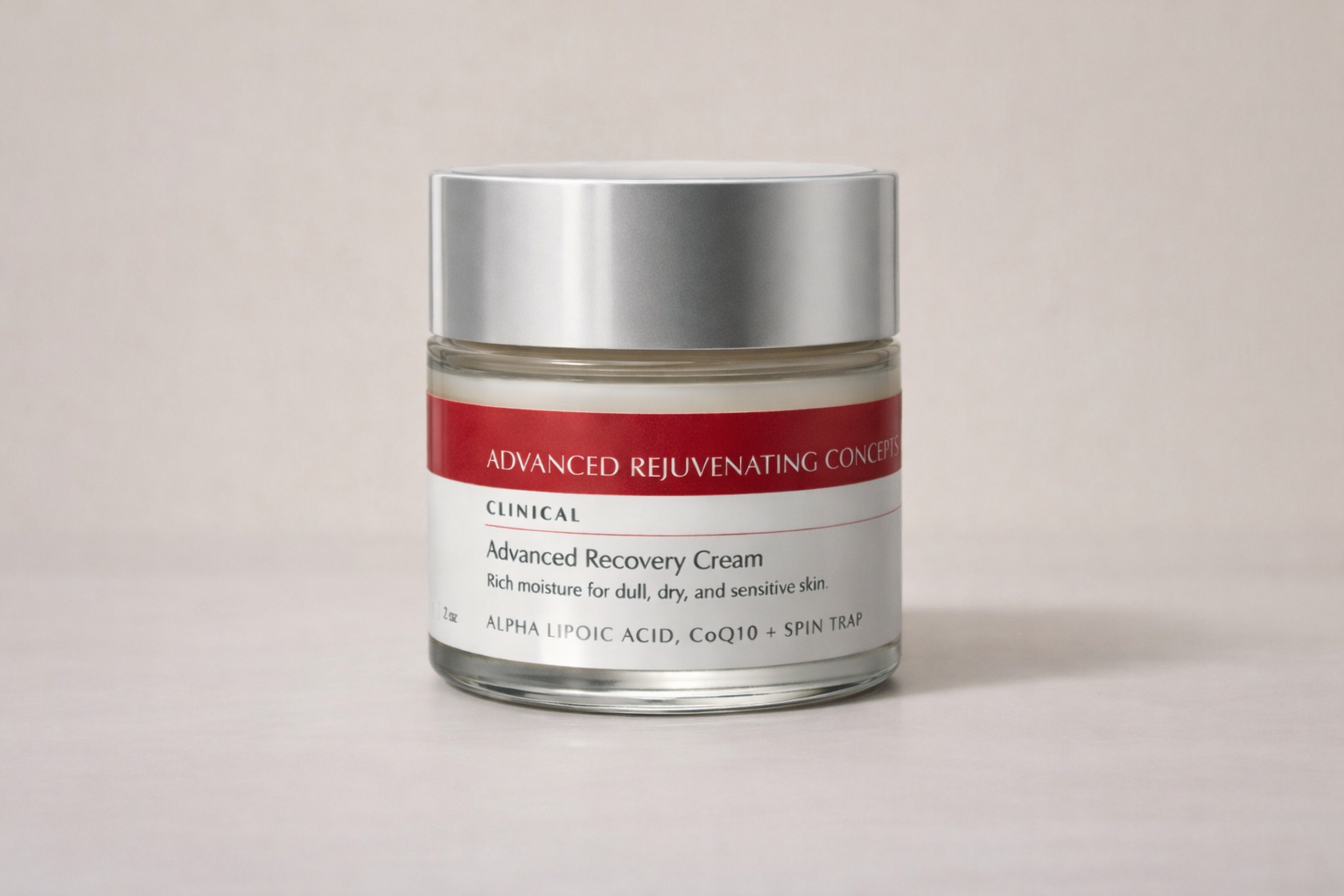 Jar of Advanced Recovery CreamCream with silver lid and red label on a beige background