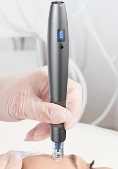 A micro-needling machine is held by a gloved hand over a person's face, likely for cosmetic or medical treatment.